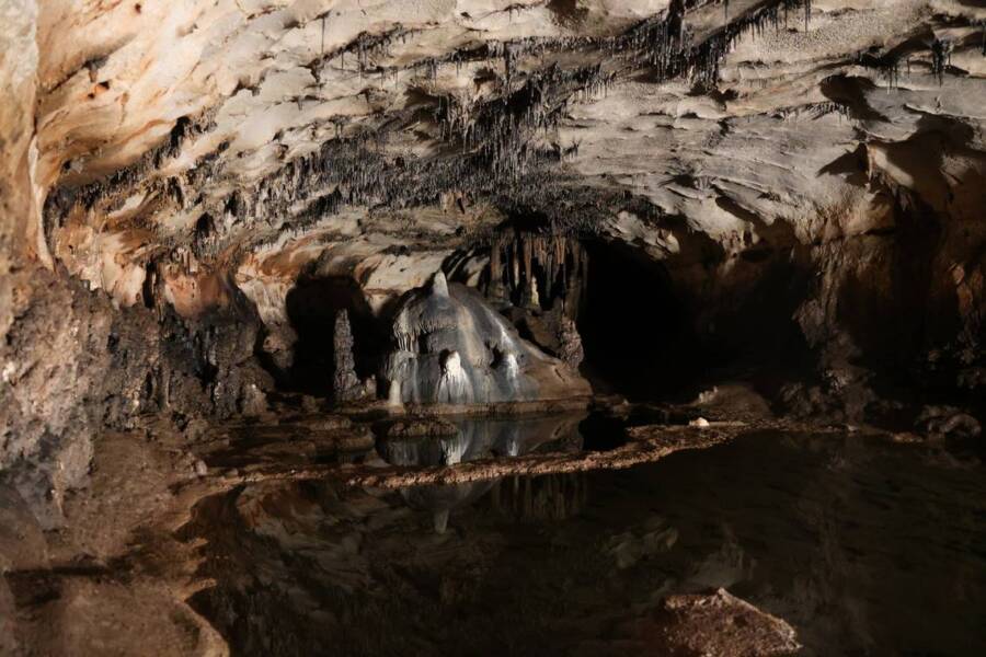 A imagem mostrar o interior da Cova de les Dones. Não é possível ver muita coisa. Apenas uma caverna profunda.